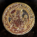 Crowned ruler holding a sceptre and orb on a gold-colored ducat replica